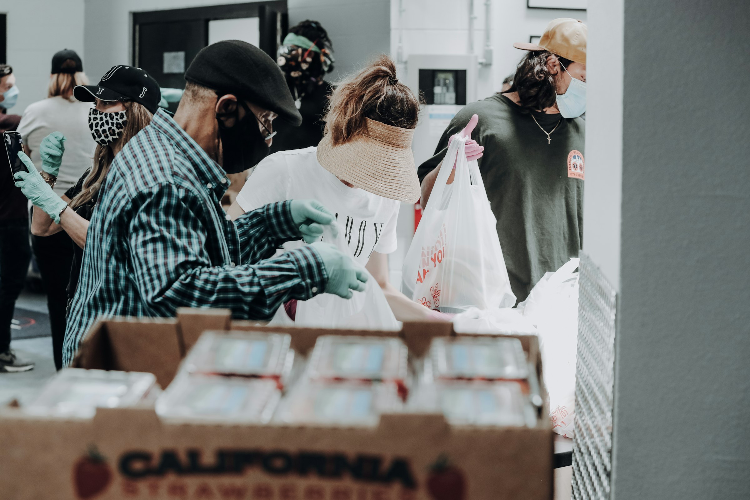 Volunteers standing in front of stacked boxes of donated food